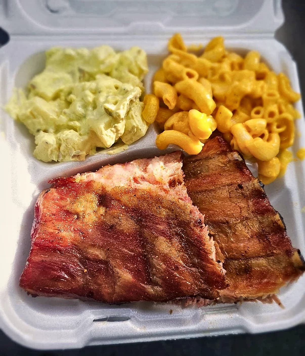 EC Smoked BBQ's ribs, macaroni and cheese and potato salad in a takeout box