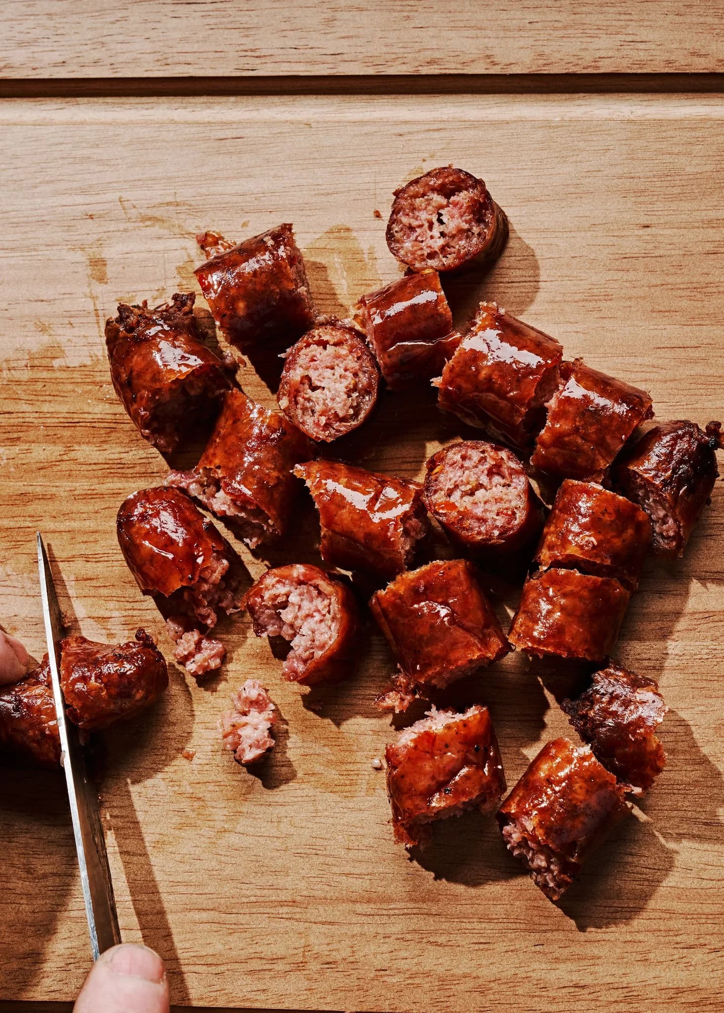 Smoked sausage cut into chunks on a wooden board