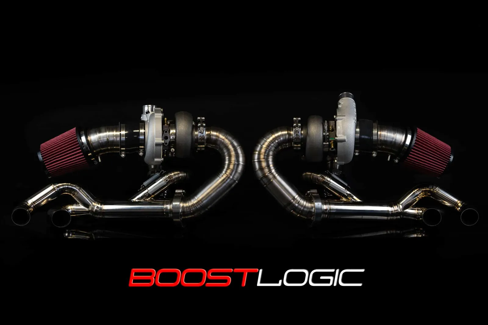 A Boost Logic twin-turbo kit for the Huracán laid out on black, two turbos with their intakes and titanium pipes, the red and white BOOSTLOGIC mark beneath