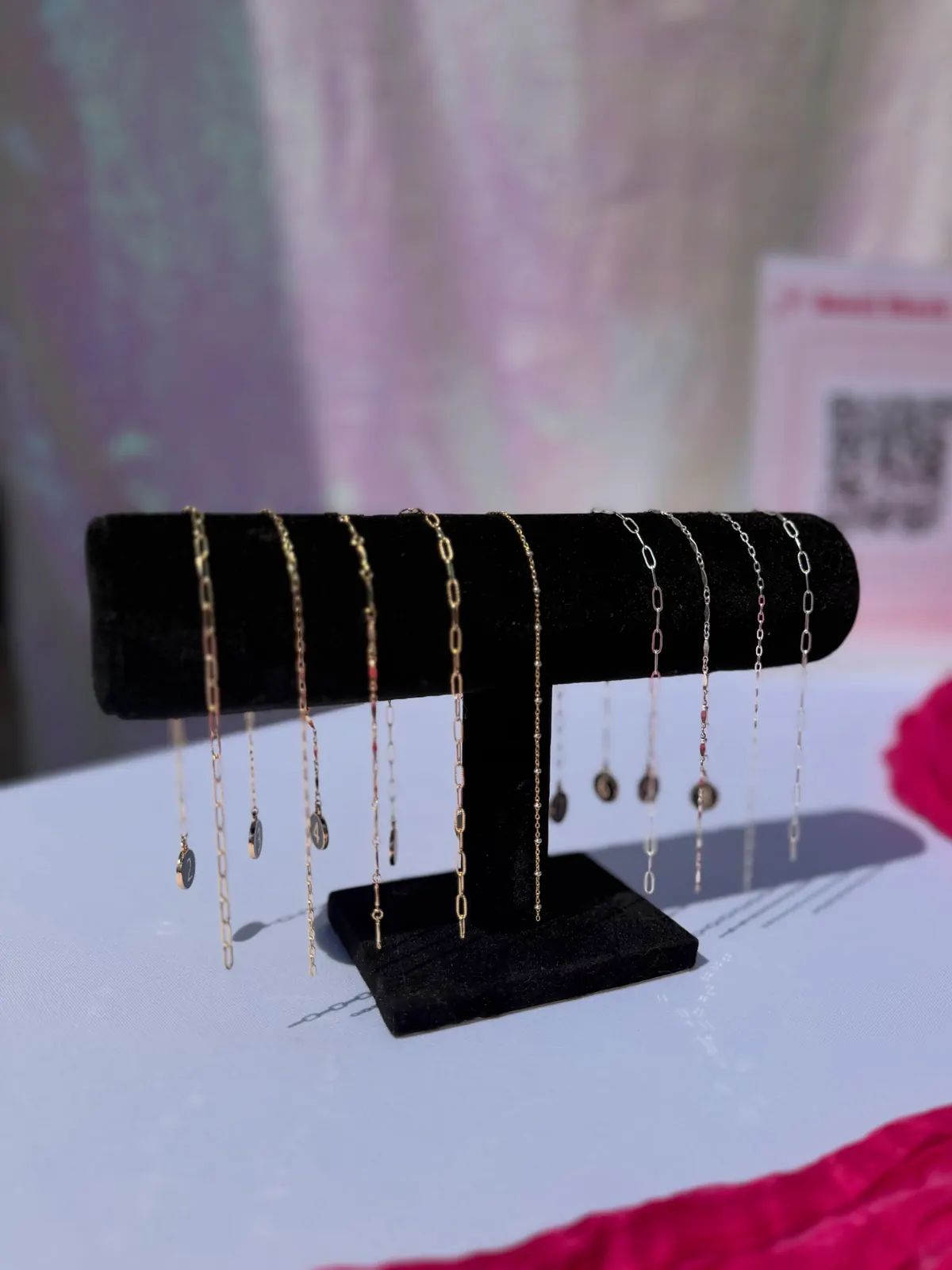 A black velvet T-bar hung with gold and silver chains, some with small round charms
