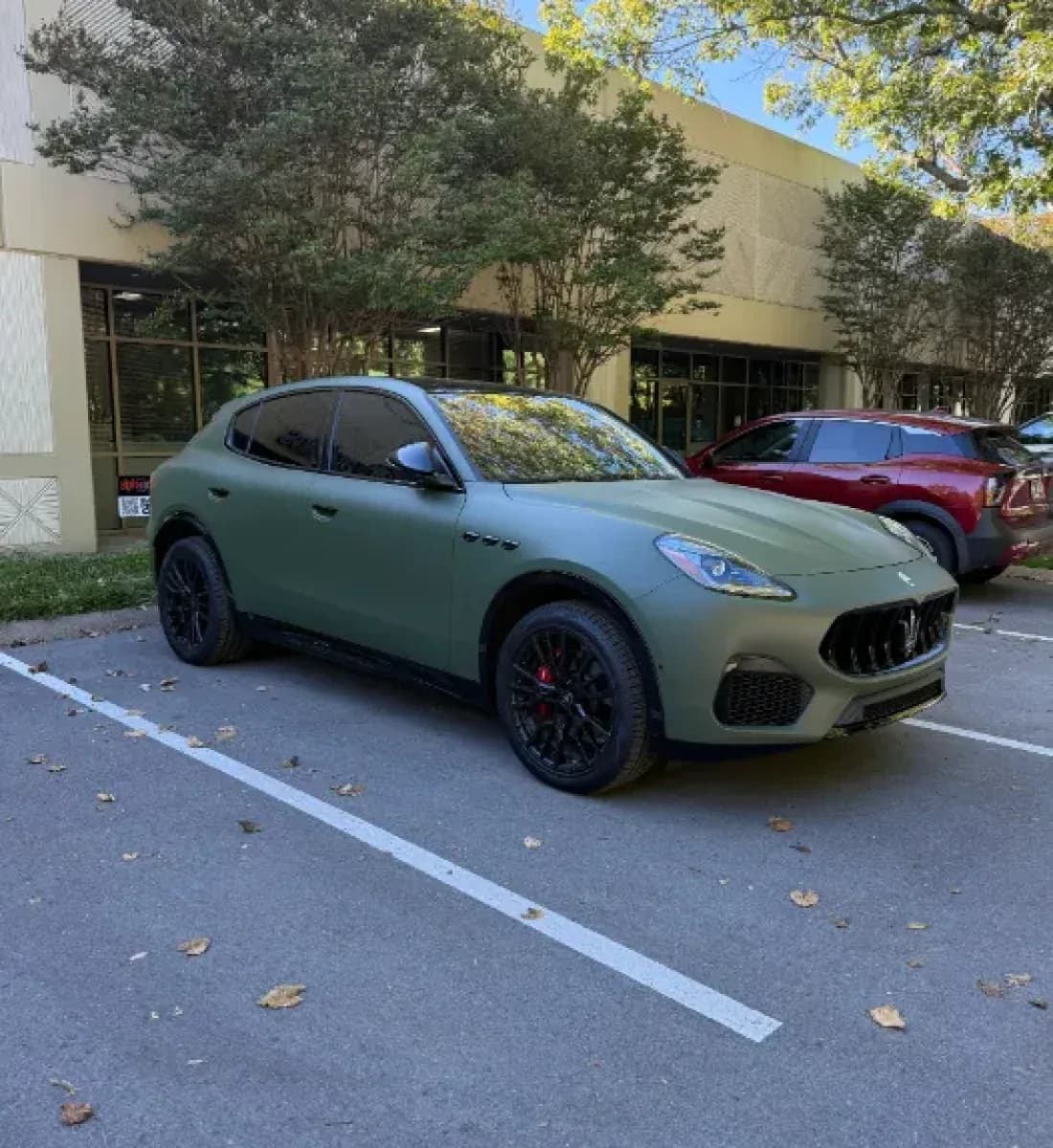 A Maserati Grecale in matte green parked outside the studio