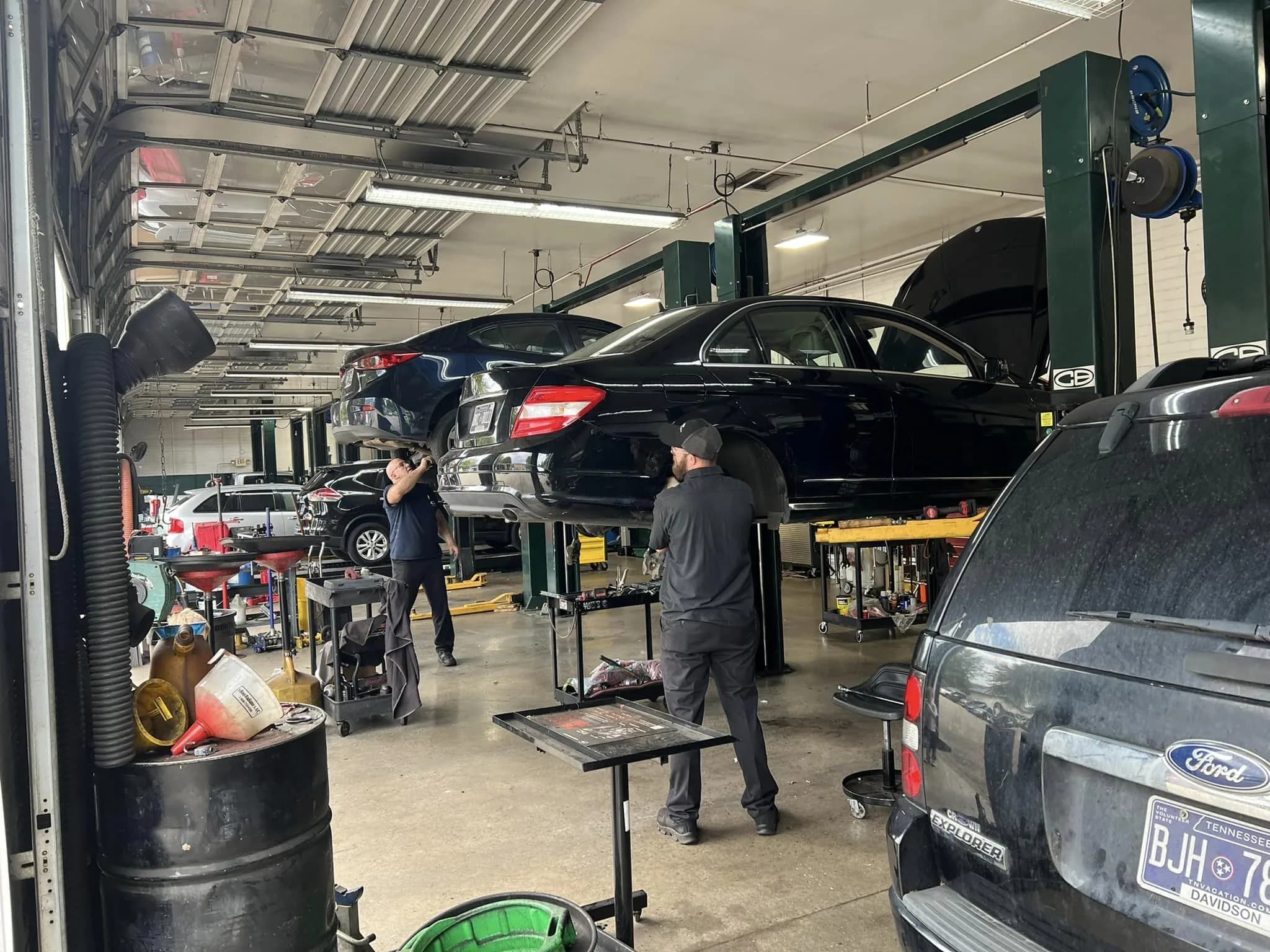 Inside a partner repair shop, cars up on lifts and a technician at work