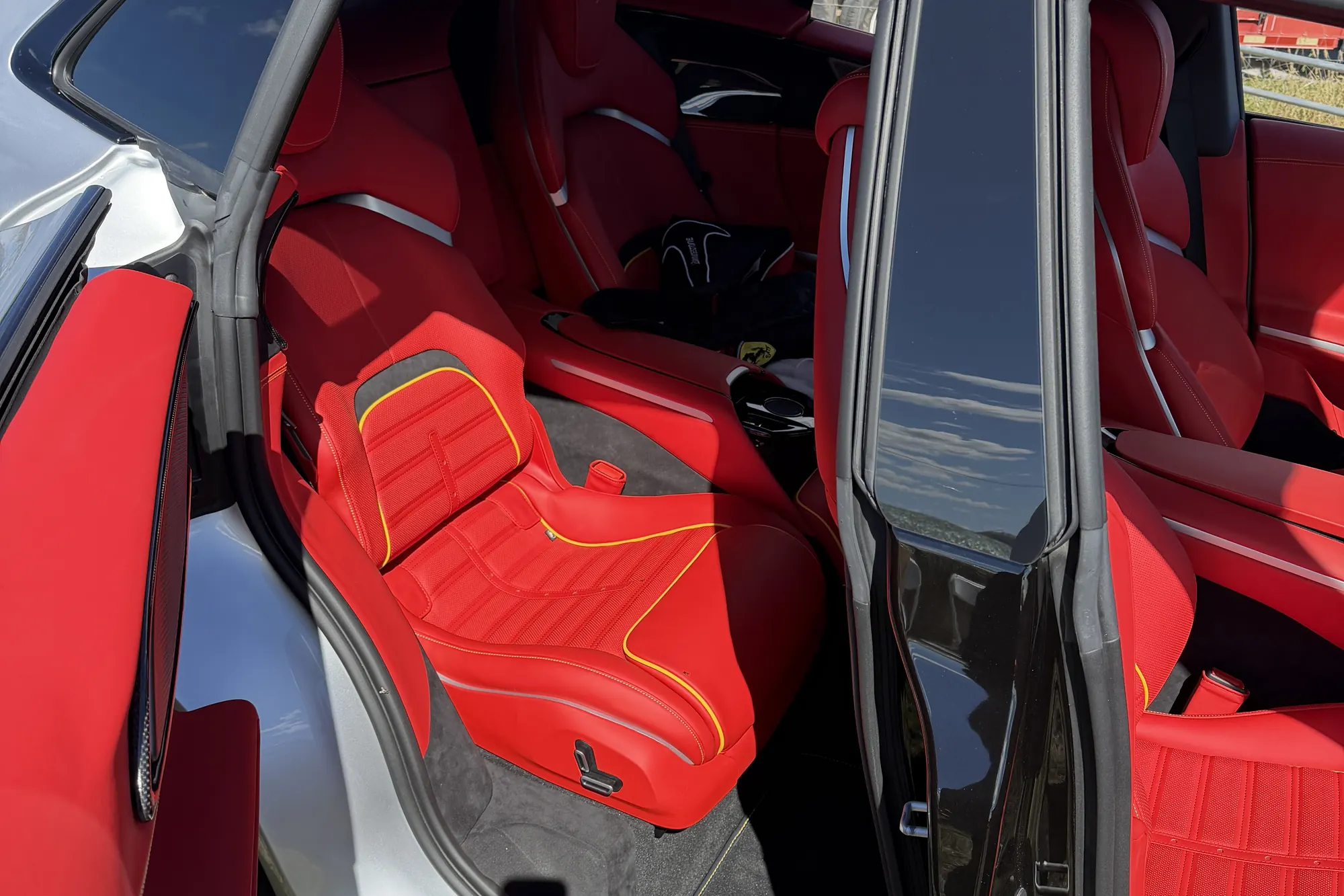 Inside the Ferrari Purosangue at the ranch, its rear-hinged back door open on red leather seats