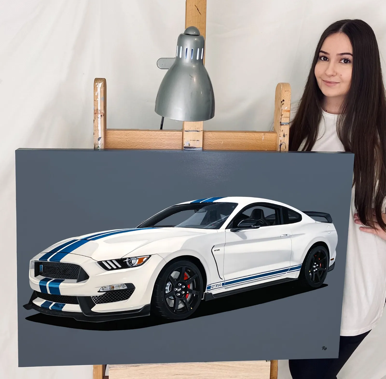 A painting of a white 2020 Mustang GT350R Heritage Edition with blue stripes, on an easel