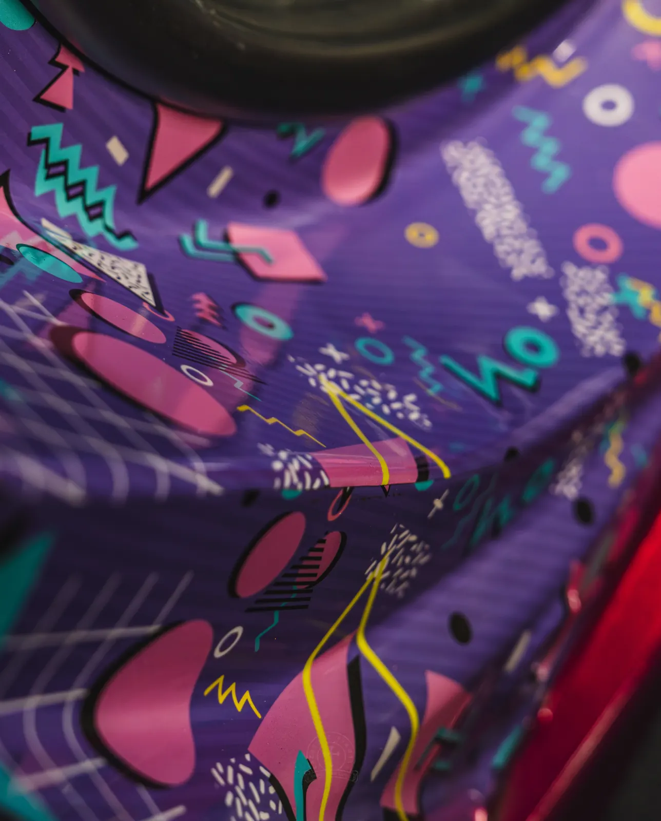 A close view of a purple retro geometric vinyl pattern wrapped around a body panel