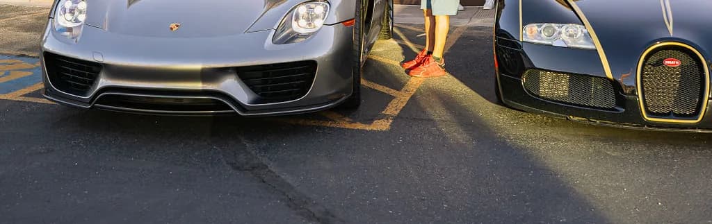 A Porsche 918 Spyder and a Bugatti Veyron parked nose out, side by side