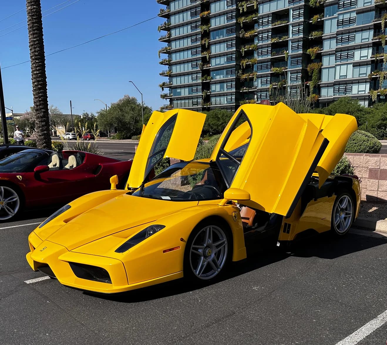 A Giallo Yellow Ferrari Enzo with both doors up, parked on the street at Tires and Timepieces