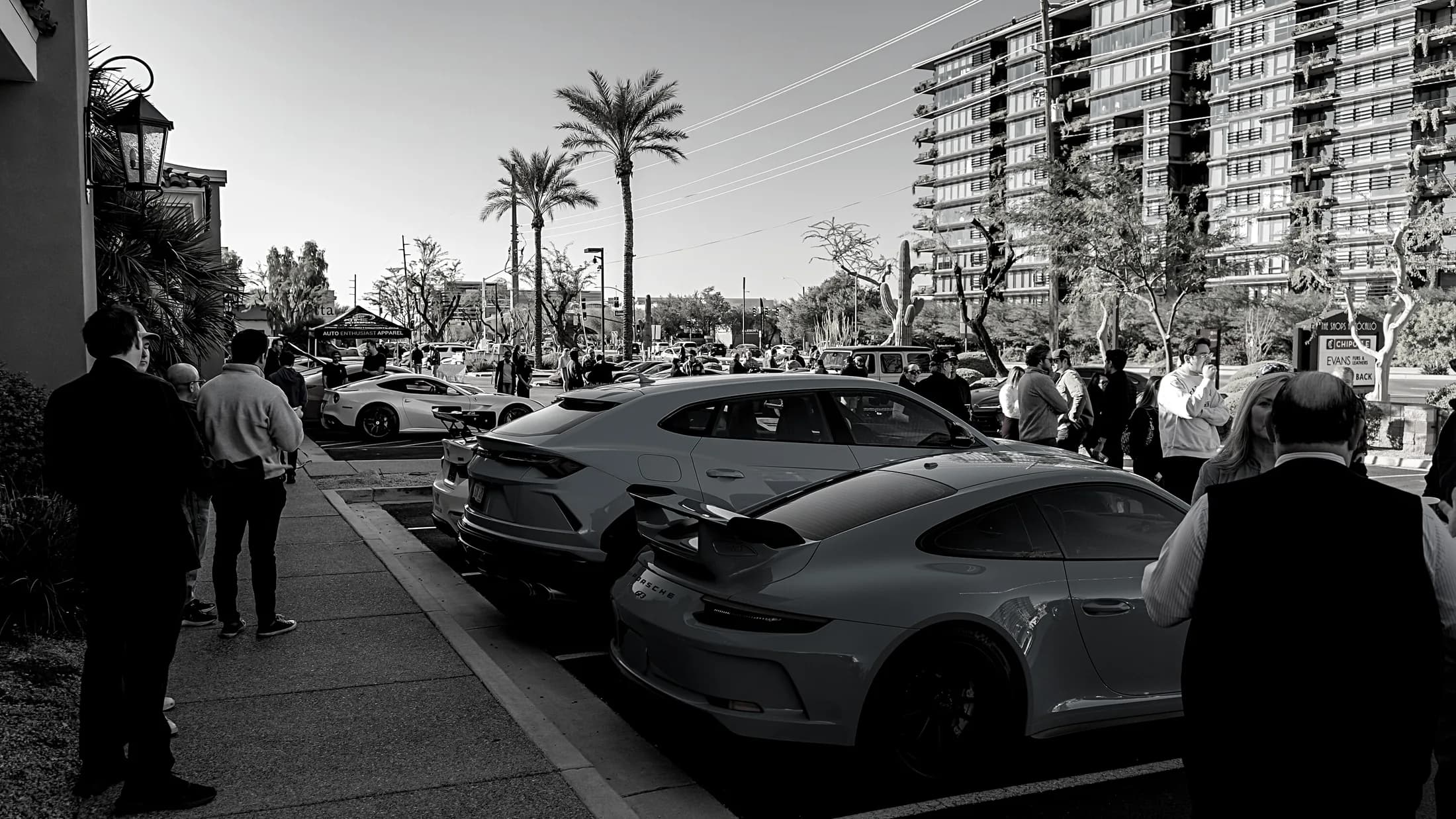 People walking the row of cars along the street